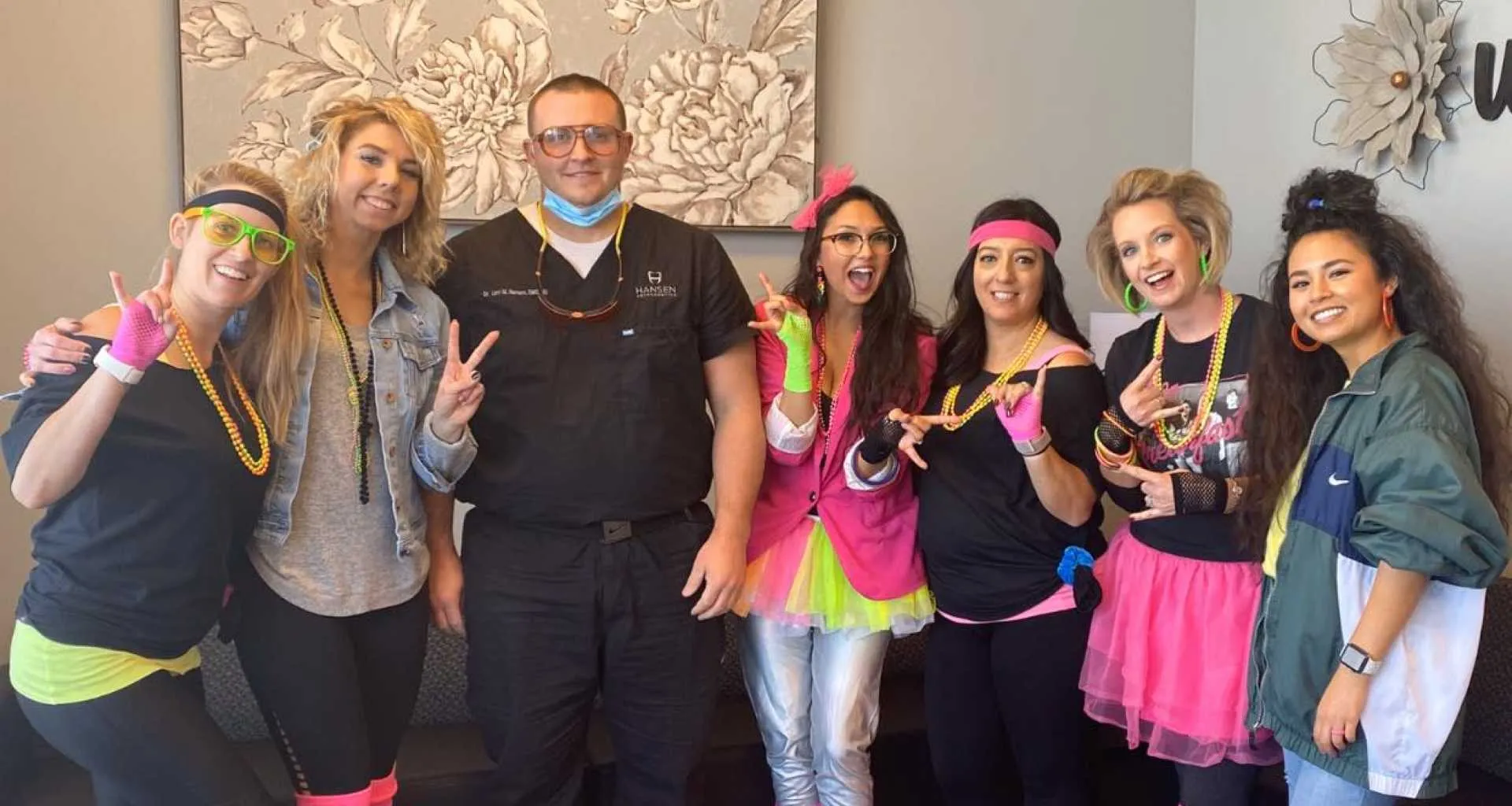 Hansen Orthodontics team in colorful costumes celebrating, showcasing a friendly and fun atmosphere in the orthodontic practice.